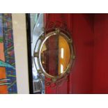 A decorative brass oval wall mirror,