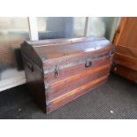 A domed travel trunk with red velour interior, wooden banding and metal handles,