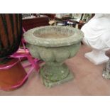A pair of Georgian style reconstituted urns the fluted bowl on a socle base,