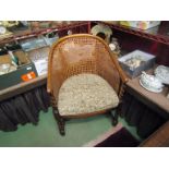 A circa 1900 oak bergère armchair with barley twist supports and "H" stretchers,