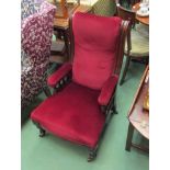 A mid Victorian mahogany ladies armchair the scrolled back over short arm turned supports on turned
