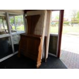 A hardwood sleigh bed with shaped ends