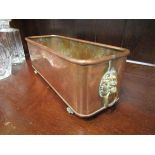 A rectangular copper planter, brass lions head ring turned handles to claw feet,