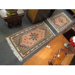 Two Tunisian wool rugs with peach ground, brown and blue geometric central medallion,