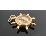 An 18ct gold charm compass in the form of a ships wheel, 12.