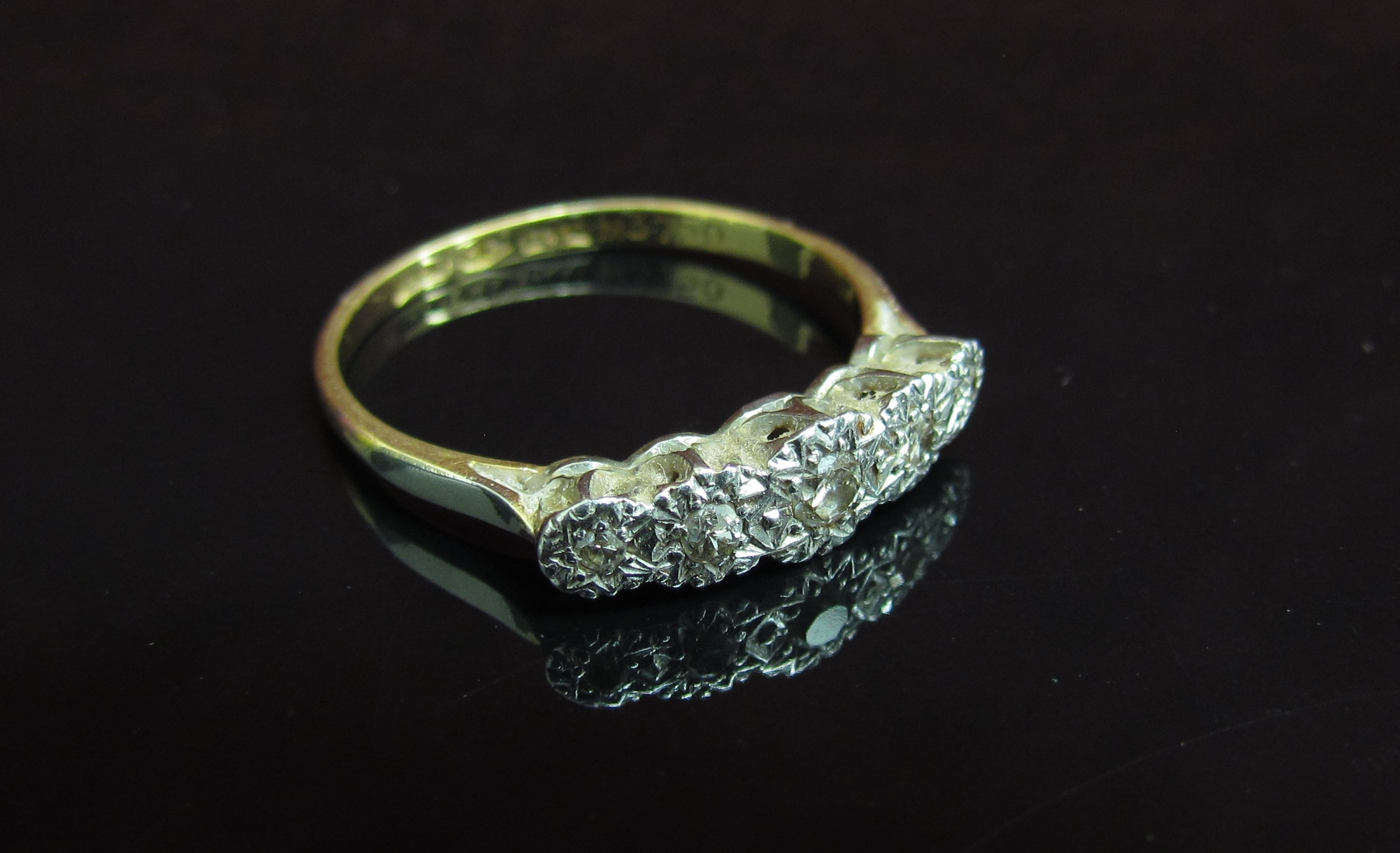 An 18ct gold platinum set five stone illusion set diamond ring. Size Q, 2.