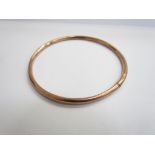 A 9ct rose gold slave bangle, dented, 7.5cm diameter, 7.