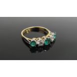 An emerald and diamond five stone ring, stamped 750/plat, .40ct diamond, .90ct emerald.