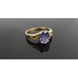 An 18ct gold tanzanite ring, the oval stone flanked by diamonds. Size R, 3.