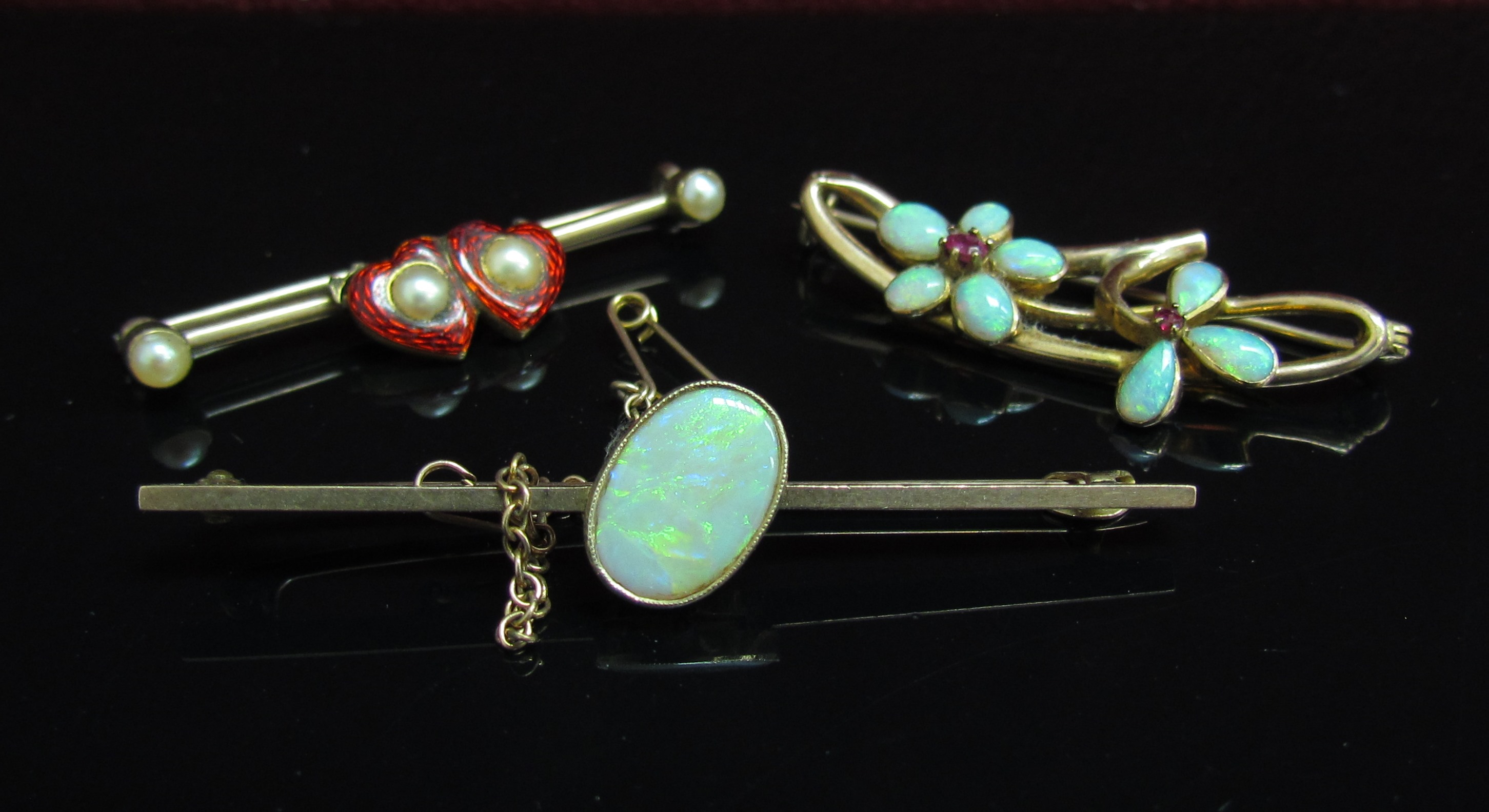 Three gold bar brooches, red enamel heart and pearl, opal and ruby flowers and oval opal examples,