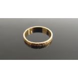 An 18ct gold band, engraved pattern. Size P, 2.