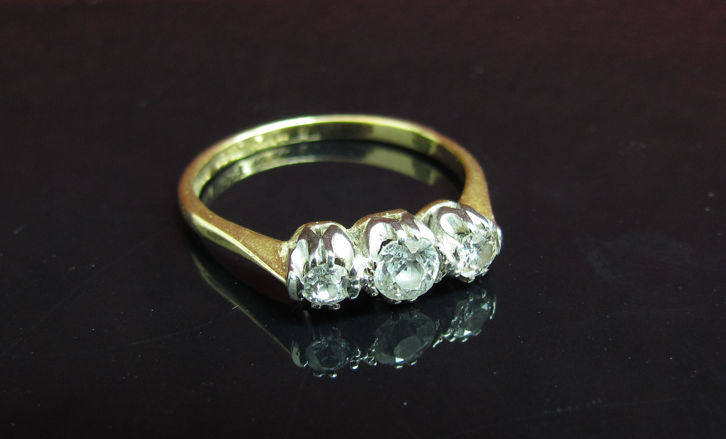 A gold three stone diamond ring, central stone .25ct flanked by .