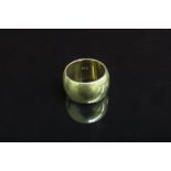 A gold band 11mm wide stamped 14k. Size O, 15.