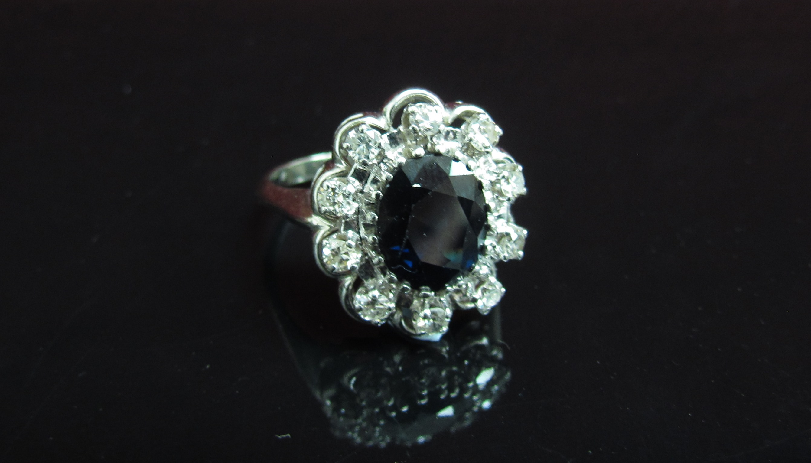 A white gold sapphire and diamond cluster ring, shank stamped 18k. Size R, 6.