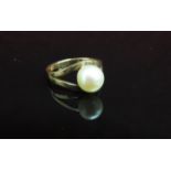 A gold ring set with single pearl in split shank stamped 14k. Size L, 3.