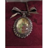 A Sterling oval pendant depicting a lady in crinoline dress,