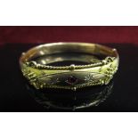 A Victorian 9ct gold bangle with scroll detail set with small old cut diamonds and ruby (dented),