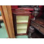 A late Victorian walnut cabinet with carved raised back over a glazed single door with key and