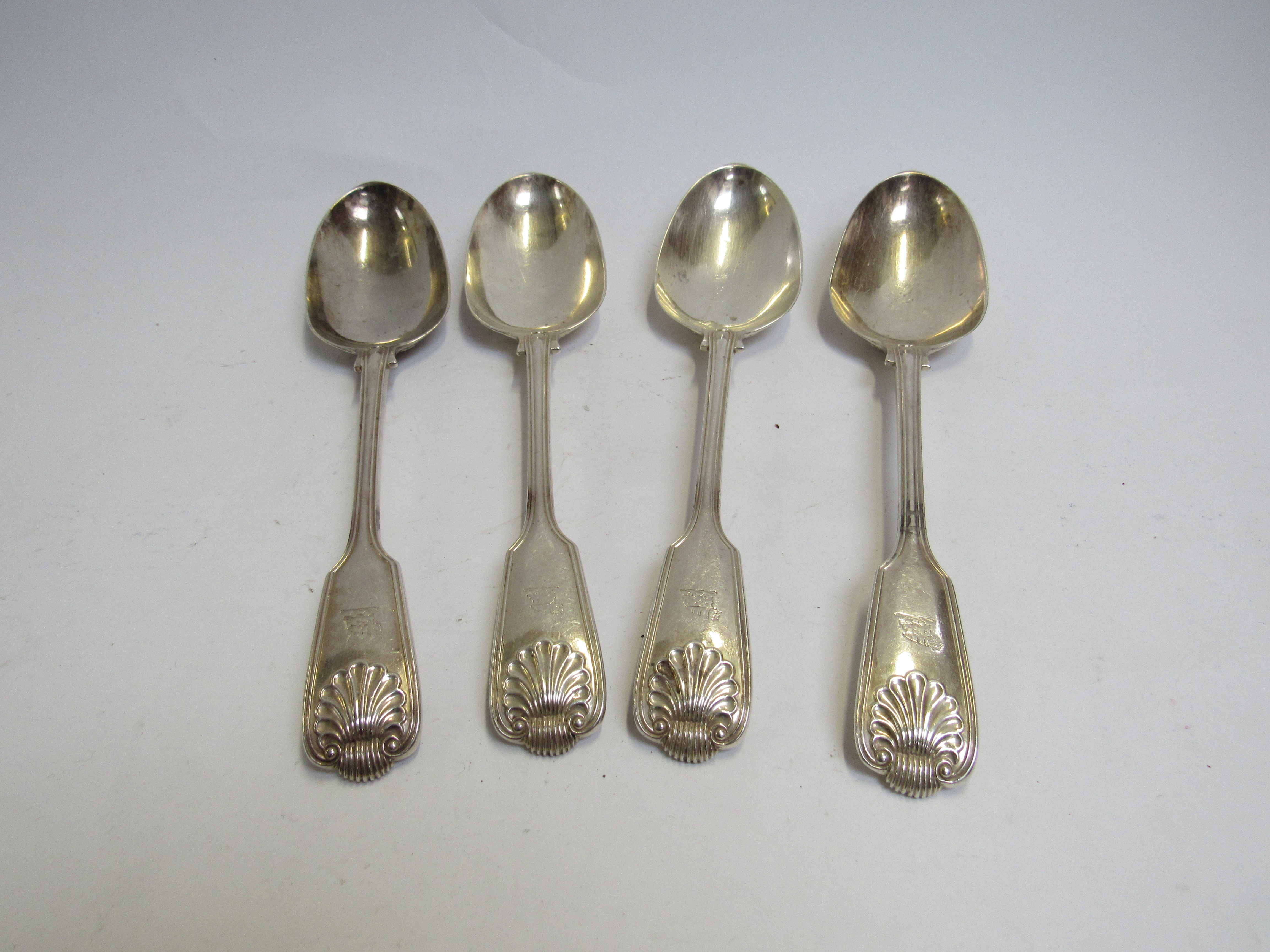 A set of four Chawner & Co (George William Adams) silver serving spoons with shell form and vehicle