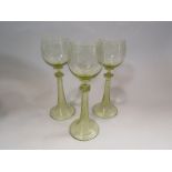 Three green tinted drinking glasses with etched bowls and twisted stems