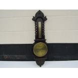 An early 20th Century English barometer with barley twist supports and brass face,