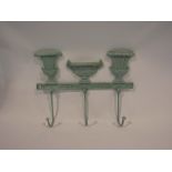 A cast iron coat rack with verdigris garden urn design