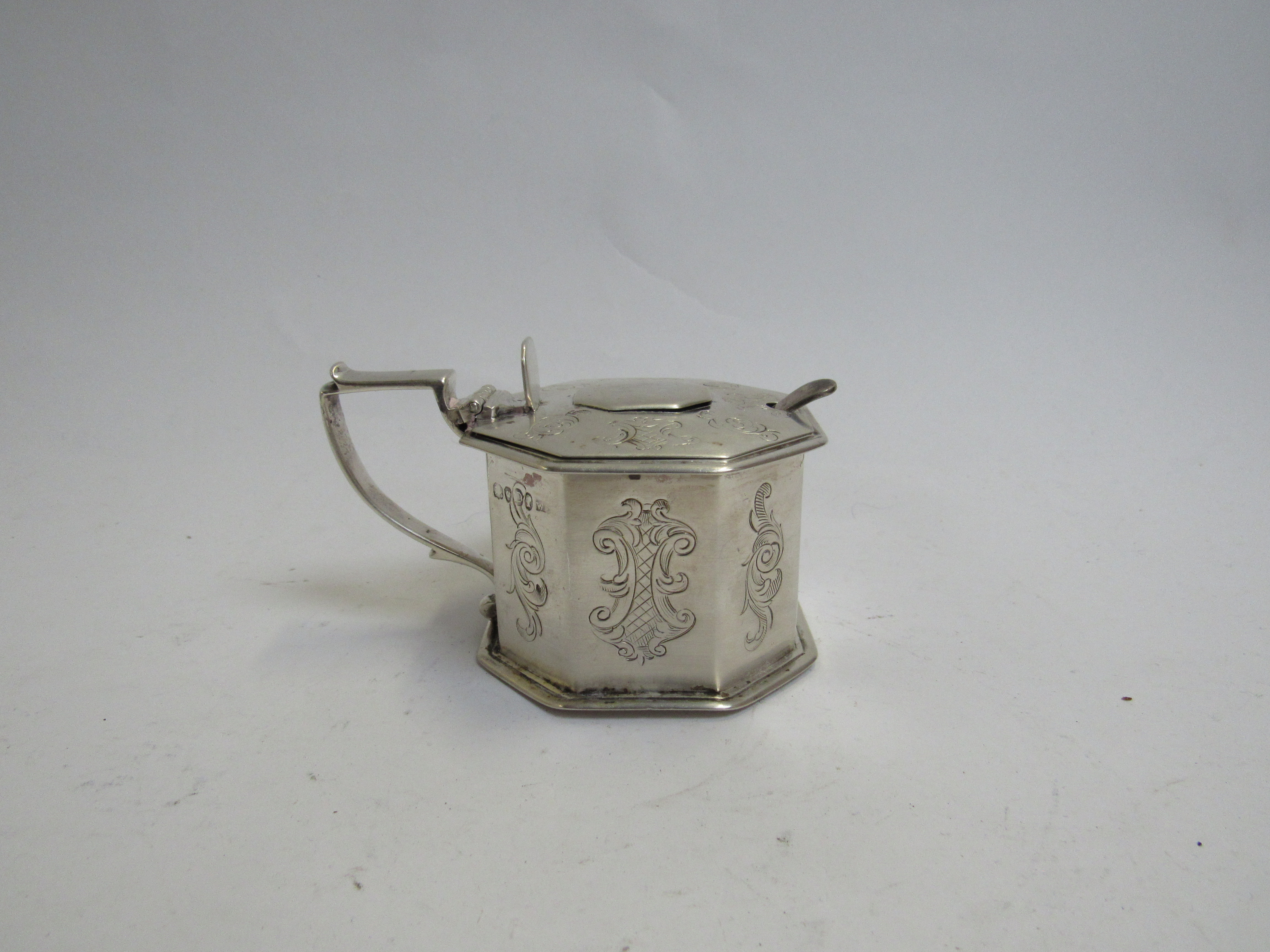 A Victorian silver mustard pot of large proportions, octagonal form with engraved panels,