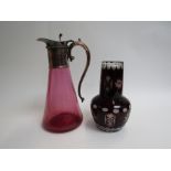 A Cranberry glass claret jug with plated neck and handle and ruby glass water jug with cup