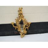 A modern highly ornate mirror with candle sconces,