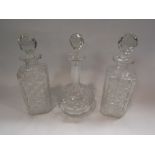 Three glass decanters with stoppers and a spare stopper