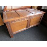 A 17th Century style panelled oak coffer with carved muntins over stile feet,