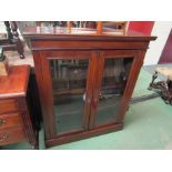 A late Victorian walnut two door glazed bookcase with key,