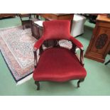 A late Victorian mahogany tub chair with pierced supports on cabriole legs on ceramic castors,