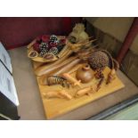 A wooden board with a selection of treen, including carved animals, wall plaques,