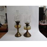 Two oil lamps with clear glass reservoirs