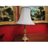 An ornate brass table lamp with shade