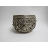 A Burmese white metal jardiniere with deep relief of military procession, elephants and horseman,