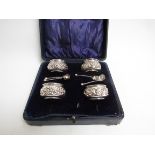 A Joseph Gloster Ltd silver set of four table salts with embossed floral design with spoons, cased,