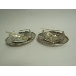 A pair of George III silver table salts, the silver bases accommodating cut glass bowls,