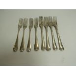 Eight Georgian silver dinner forks, various monograms, makers and dates, marks rubbed,