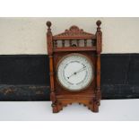 A late Victorian wall hanging barometer with carved case spindle detail,