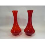 A pair of red glass vases,