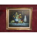 A still-life oil on canvas depicting fruit and grapes on table, signed lower right, gilt framed,