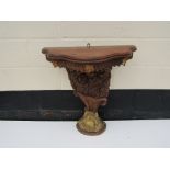 A 20th Century carved Indian hardwood console table with serpentine top, floral high relief carving,