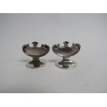 A pair of silver crescent shaped menu holders on circular bases, London 1904, 3.
