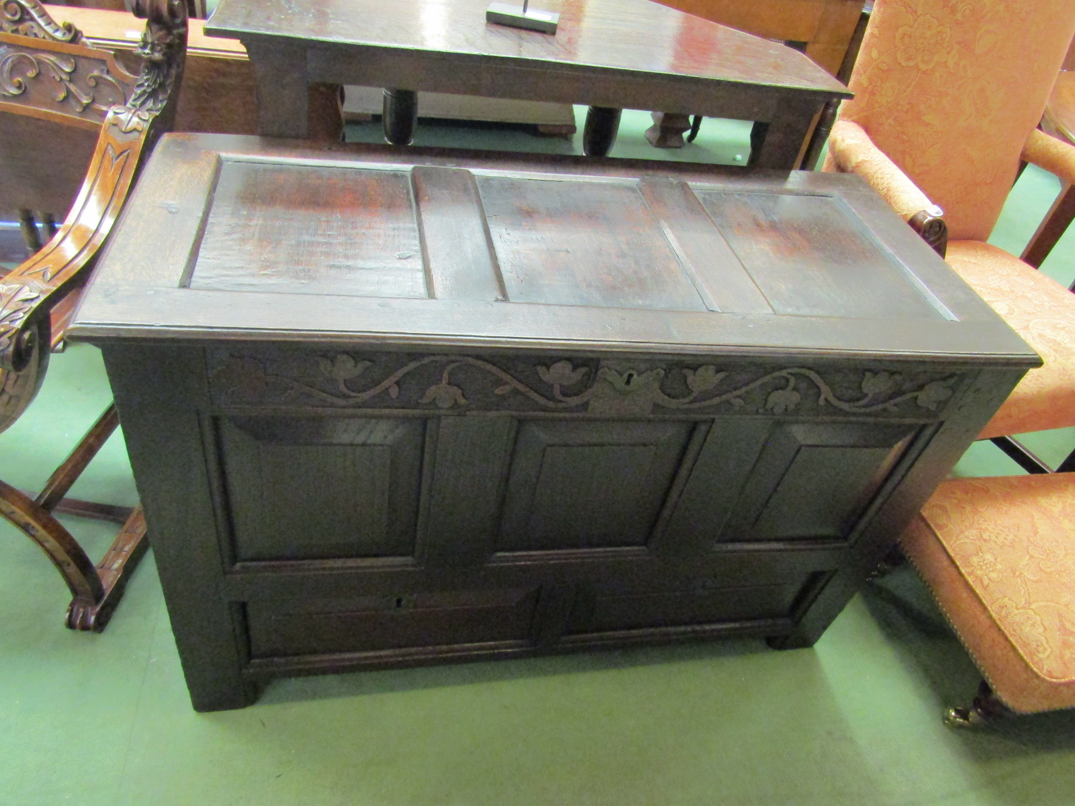 An 18th Century carved oak coffer with two faux drawers, the split hinge top over stile feet,