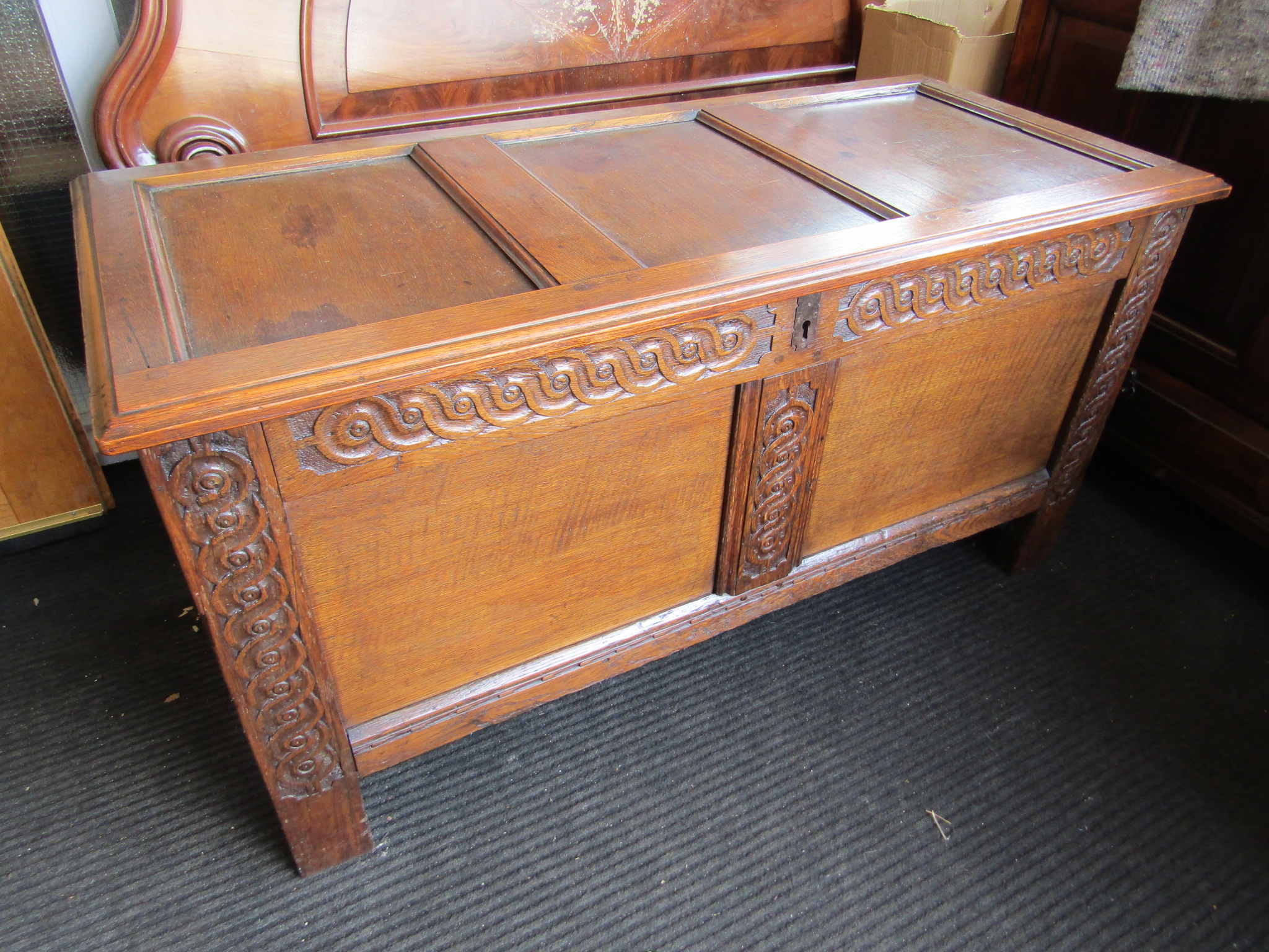 A 17th Century style panelled oak coffer with carved muntins over stile feet, - Image 4 of 6