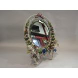 A Meissen style ceramic easel back mirror with cherub and floral detail