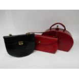 A red vinyl vanity case with looped fabric interior and two 1950's handbags in red and black