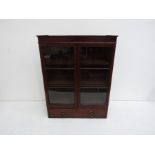 A George III flame mahogany glazed display cabinet with shelved interior over a drawer with brass